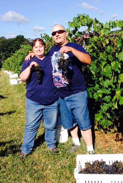 couple holding grape cluster - washington county guide